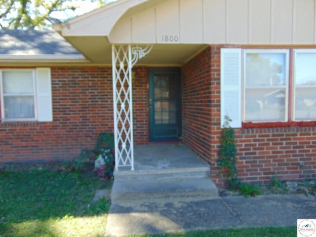 property entrance featuring brick siding