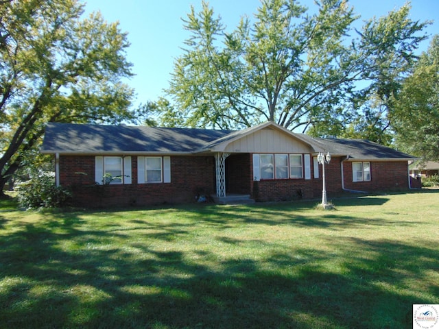ranch-style house featuring a front yard and brick siding