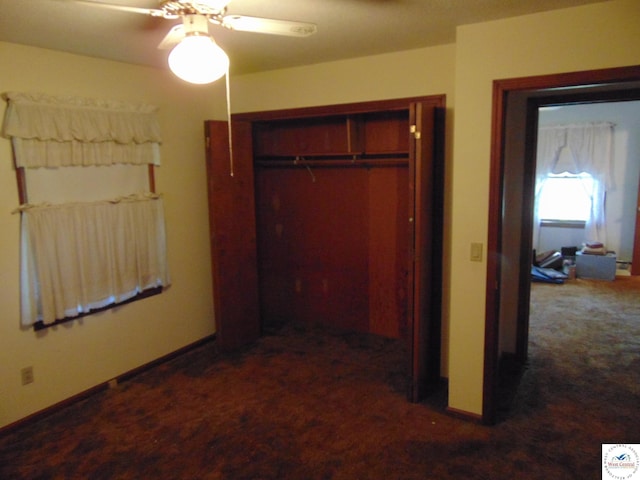 bedroom featuring dark colored carpet, ceiling fan, baseboards, and a closet