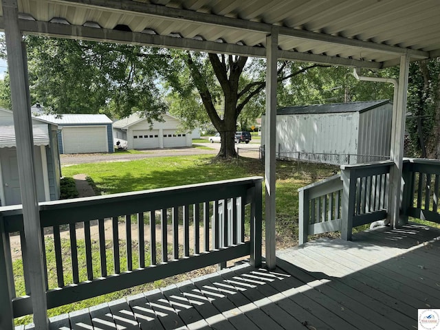 1404 S Grand Ave, Sedalia, MO 65301 - wooden terrace with a storage shed, a lawn, an outbuilding, and a garage
