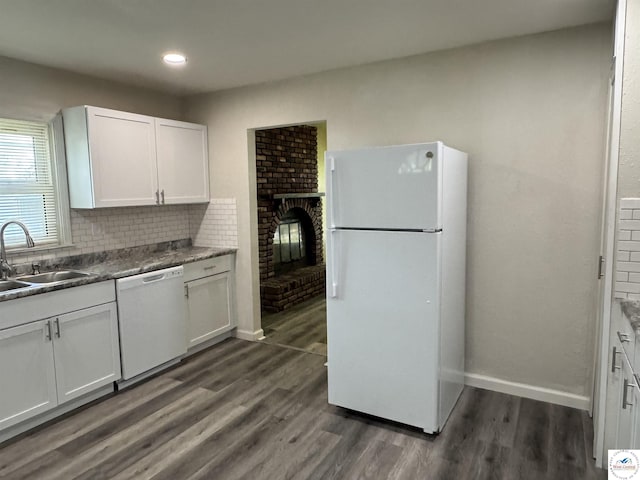 1404 S Grand Ave, Sedalia, MO 65301 - kitchen featuring decorative backsplash, dark wood-style flooring, a fireplace, white appliances, and a sink