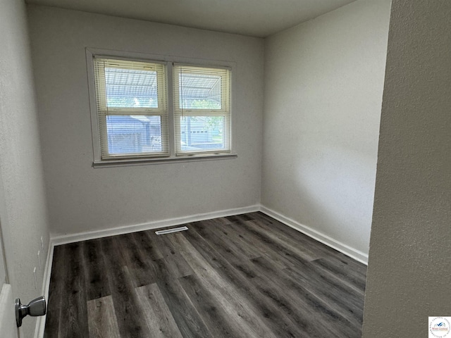 1404 S Grand Ave, Sedalia, MO 65301 - spare room with visible vents, dark wood-style flooring, and baseboards