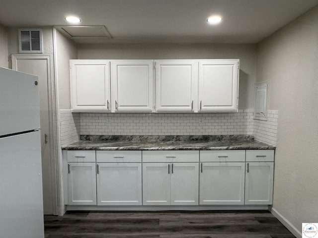 1404 S Grand Ave, Sedalia, MO 65301 - kitchen with visible vents, freestanding refrigerator, white cabinets, and dark wood-style floors
