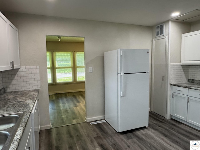 1404 S Grand Ave, Sedalia, MO 65301 - kitchen with visible vents, decorative backsplash, white appliances, white cabinetry, and a sink