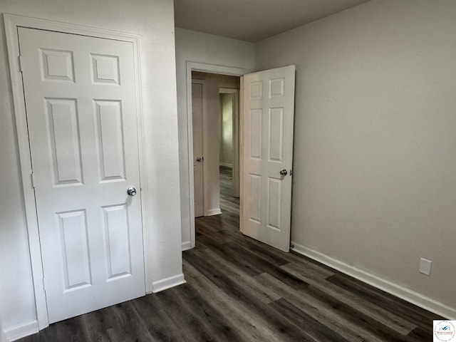 1404 S Grand Ave, Sedalia, MO 65301 - unfurnished bedroom with baseboards and dark wood finished floors