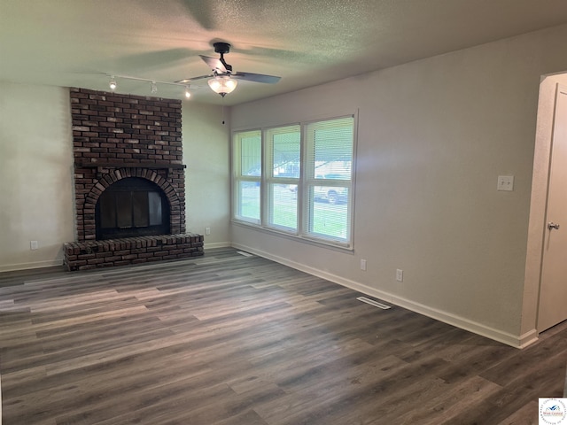 1404 S Grand Ave, Sedalia, MO 65301 - unfurnished living room with track lighting, baseboards, ceiling fan, and dark wood-style flooring