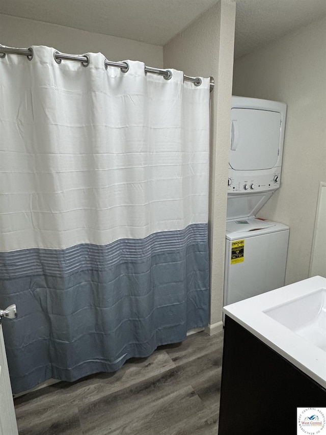 1404 S Grand Ave, Sedalia, MO 65301 - bathroom featuring stacked washer / drying machine, wood finished floors, and vanity