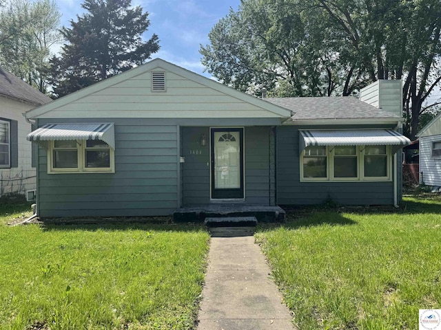 1404 S Grand Ave, Sedalia, MO 65301 - view of front facade with a chimney and a front lawn