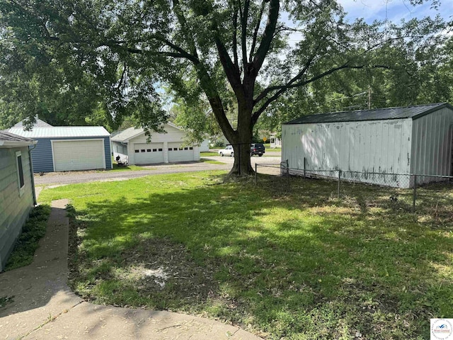 1404 S Grand Ave, Sedalia, MO 65301 - view of yard featuring a garage, fence, and an outbuilding