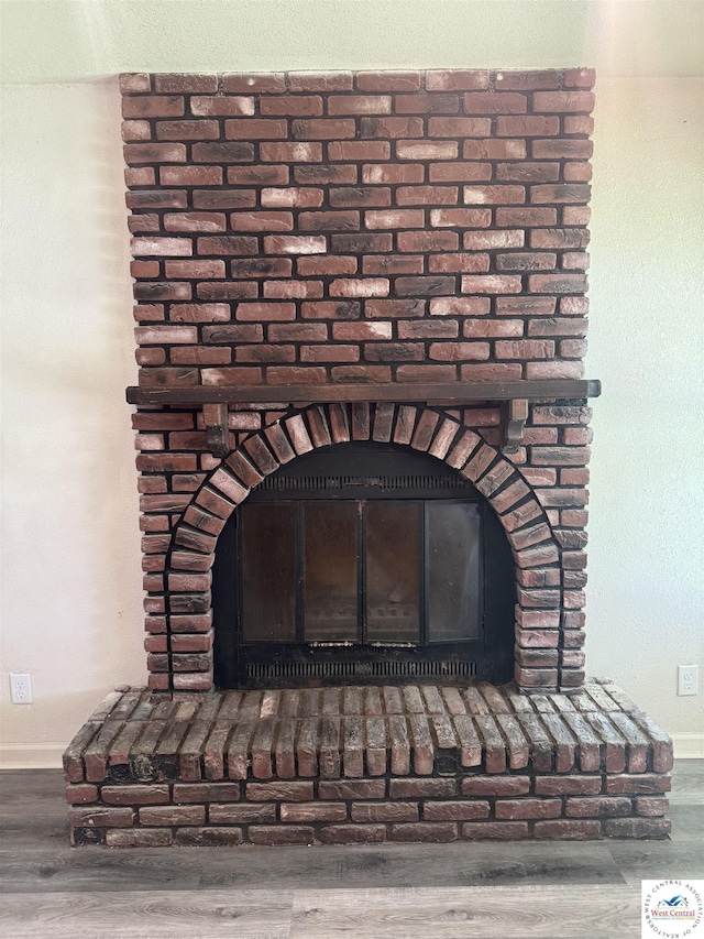 1404 S Grand Ave, Sedalia, MO 65301 - details featuring baseboards, a brick fireplace, and wood finished floors