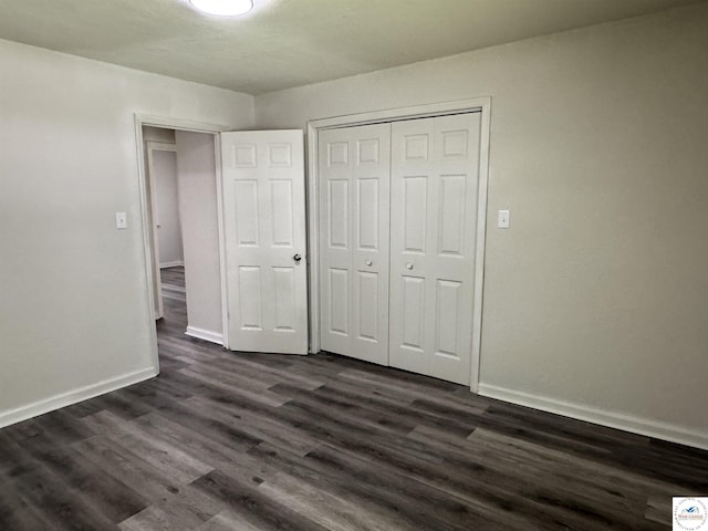 1404 S Grand Ave, Sedalia, MO 65301 - unfurnished bedroom with dark wood-type flooring, baseboards, and a closet