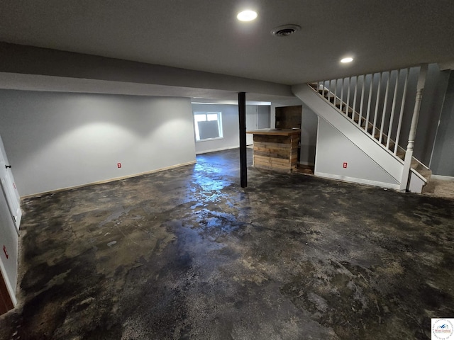 below grade area featuring visible vents, recessed lighting, stairs, and baseboards
