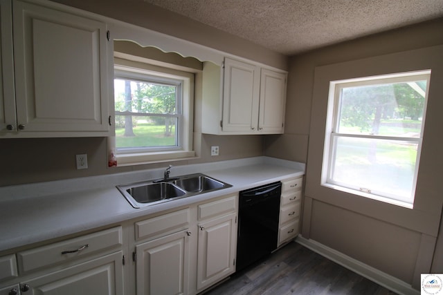 kitchen with a textured ceiling, a sink, light countertops, dishwasher, and wood finished floors