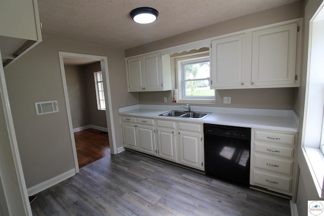 kitchen featuring a sink, black dishwasher, visible vents, light countertops, and a textured ceiling