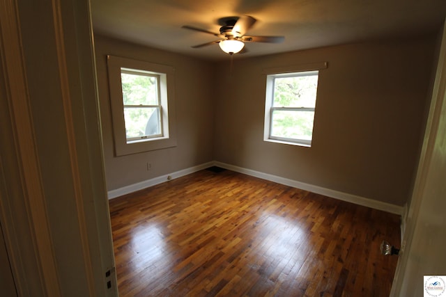 unfurnished room with wood finished floors, ceiling fan, and baseboards