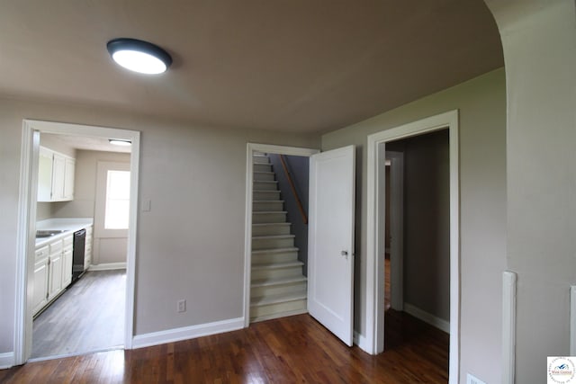 interior space with dishwasher, baseboards, white cabinetry, and dark wood-type flooring