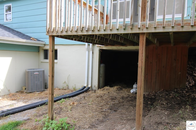 view of side of home with central air condition unit and a shingled roof