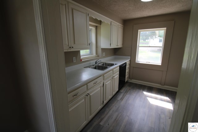 kitchen featuring black dishwasher, light countertops, a sink, white cabinetry, and a textured ceiling