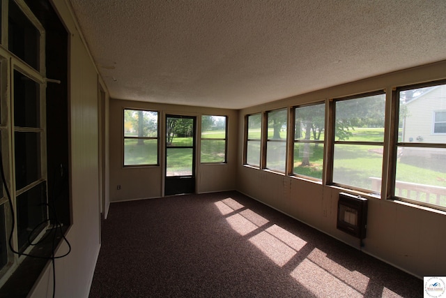 unfurnished sunroom featuring a textured ceiling, carpet, and plenty of natural light
