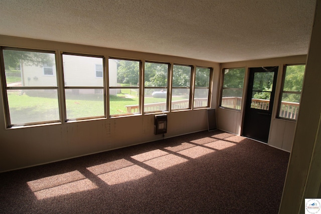 unfurnished sunroom featuring carpet floors and a textured ceiling