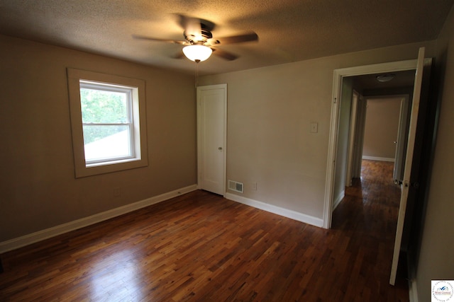 unfurnished room featuring baseboards, visible vents, ceiling fan, and dark wood-type flooring