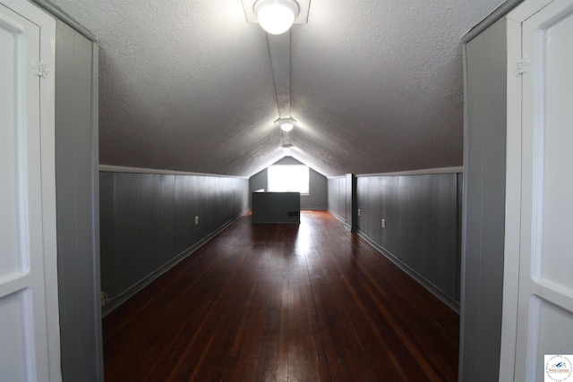 bonus room featuring lofted ceiling, hardwood / wood-style flooring, and baseboards