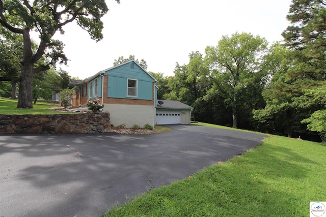 view of property exterior with aphalt driveway and a yard