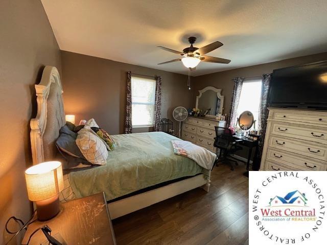 412 E Walnut St, Clinton, MO 64735 - bedroom featuring multiple windows, dark wood finished floors, and a ceiling fan