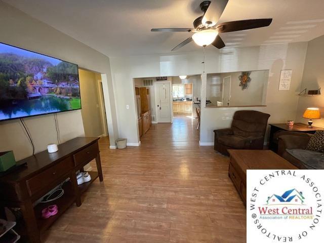 412 E Walnut St, Clinton, MO 64735 - living area with a ceiling fan, wood finished floors, and baseboards