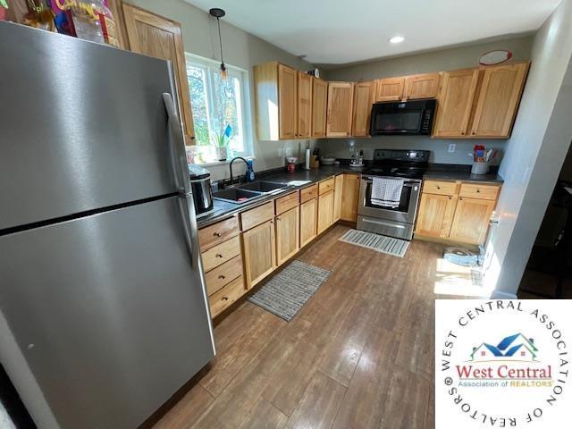 412 E Walnut St, Clinton, MO 64735 - kitchen with appliances with stainless steel finishes, a sink, dark countertops, light brown cabinetry, and recessed lighting