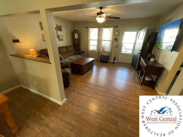 412 E Walnut St, Clinton, MO 64735 - living room with ceiling fan, wood finished floors, and baseboards