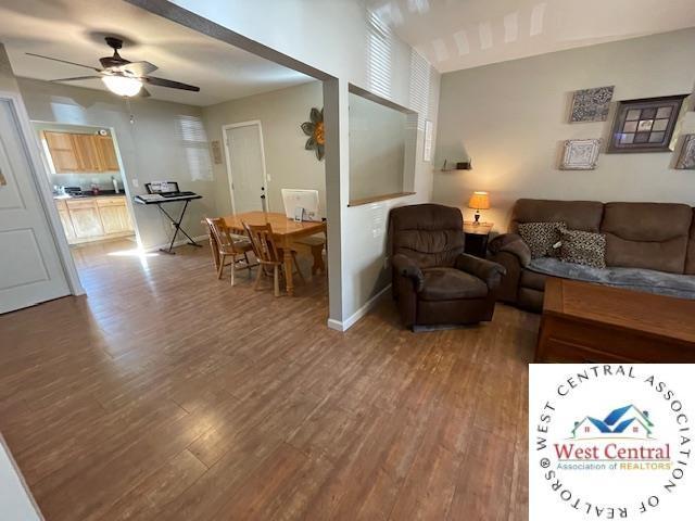 412 E Walnut St, Clinton, MO 64735 - living room with a ceiling fan, wood finished floors, and baseboards