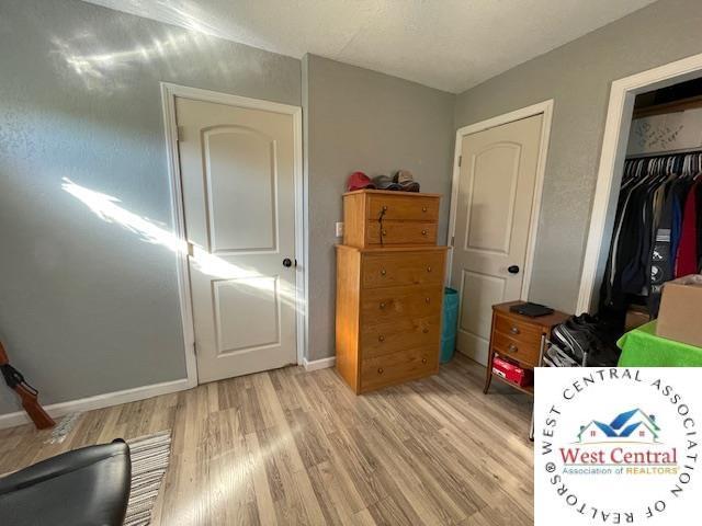 412 E Walnut St, Clinton, MO 64735 - bedroom with light wood-style flooring, baseboards, and a closet