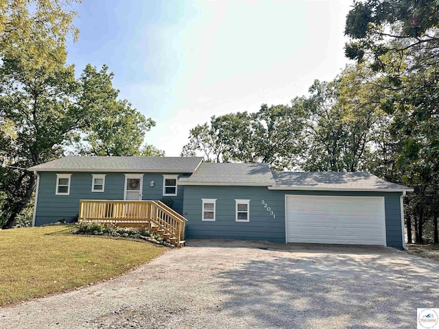 single story home with a garage, a front lawn, and driveway