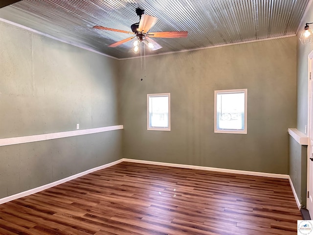 unfurnished room with ornamental molding, a ceiling fan, wood finished floors, and baseboards