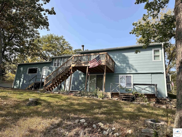back of house with a deck, a yard, and stairs