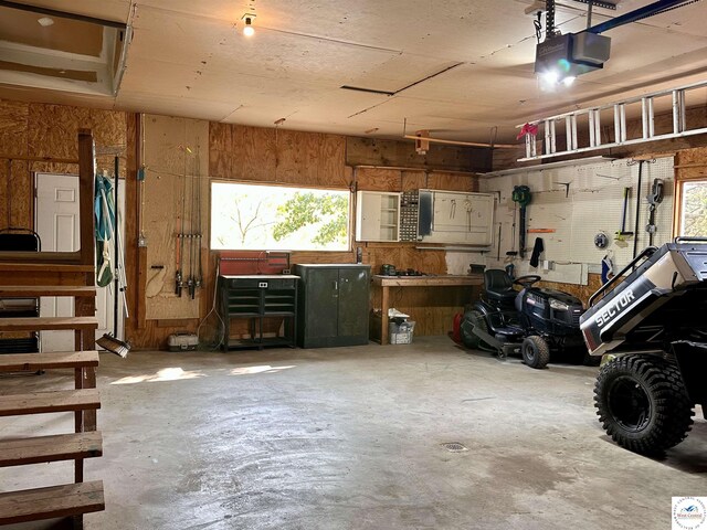 garage with a workshop area and a garage door opener