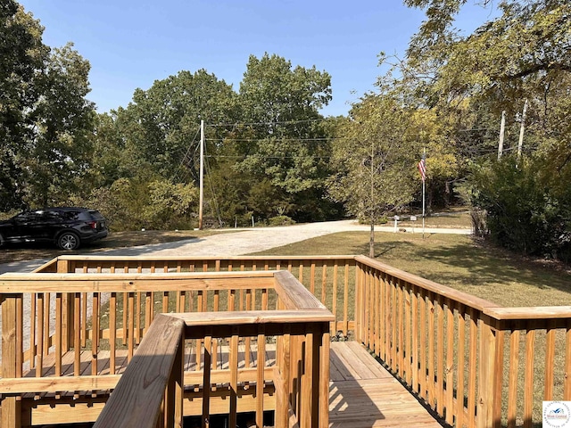 wooden terrace featuring a lawn