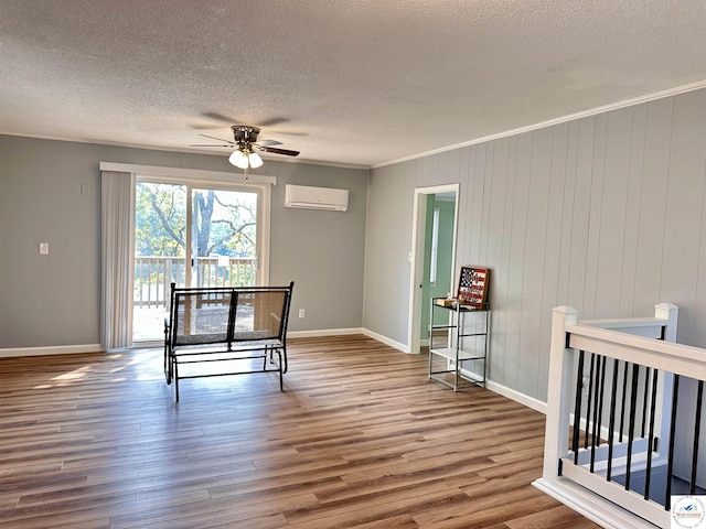 dining room with a wall unit AC, ceiling fan, a textured ceiling, and wood finished floors