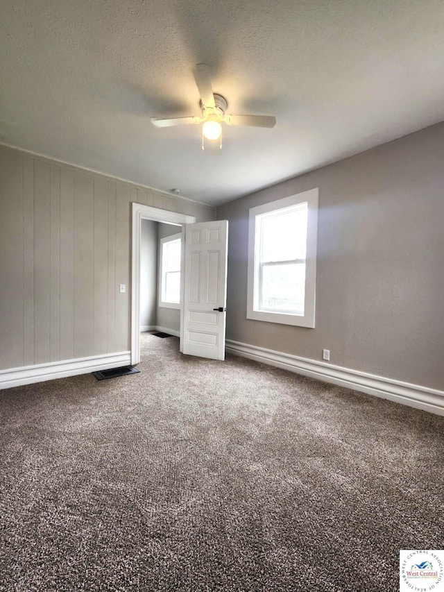 spare room featuring baseboards, ceiling fan, a textured ceiling, and carpet flooring