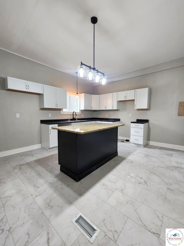 kitchen with visible vents, white cabinets, marble finish floor, and baseboards