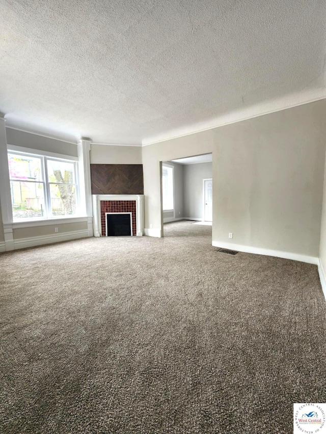 unfurnished living room with a textured ceiling, baseboards, carpet, and a fireplace