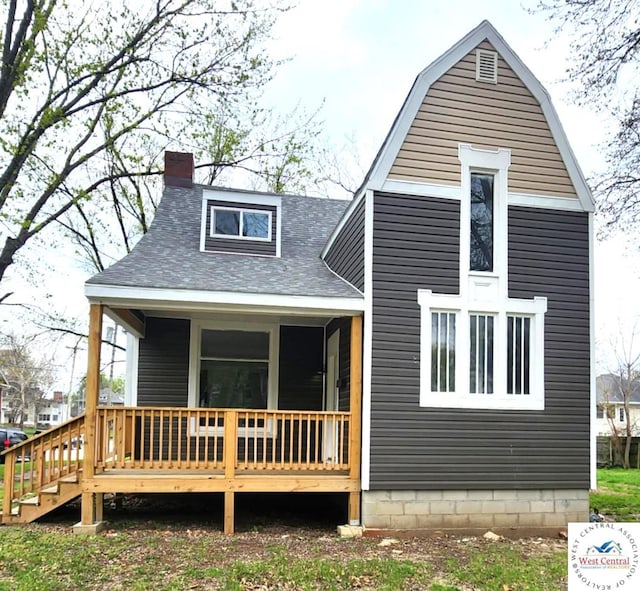 back of house featuring a chimney and a shingled roof