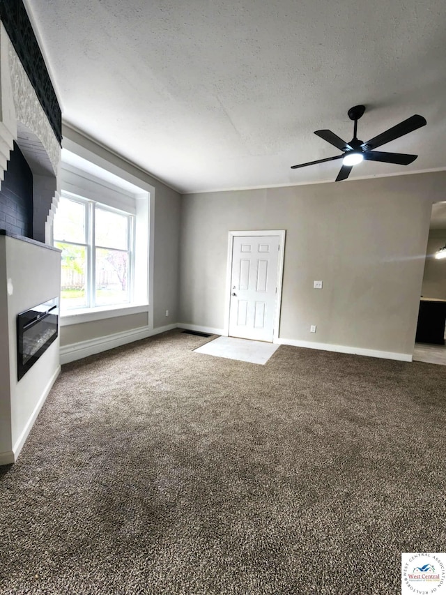 unfurnished living room with baseboards, a ceiling fan, carpet flooring, and a glass covered fireplace