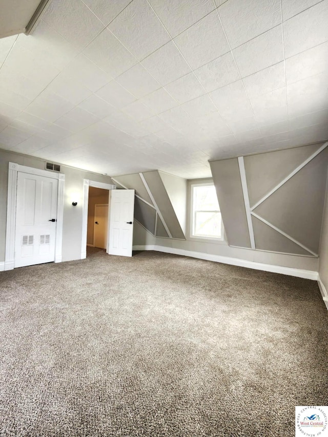 additional living space with visible vents, carpet, and baseboards