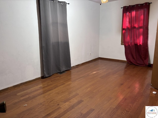 spare room featuring wood finished floors and baseboards
