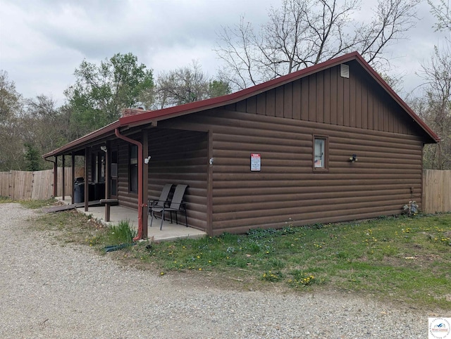 418 W Gravel St, Clinton, MO 64735 - view of property exterior with fence, a patio, and log veneer siding