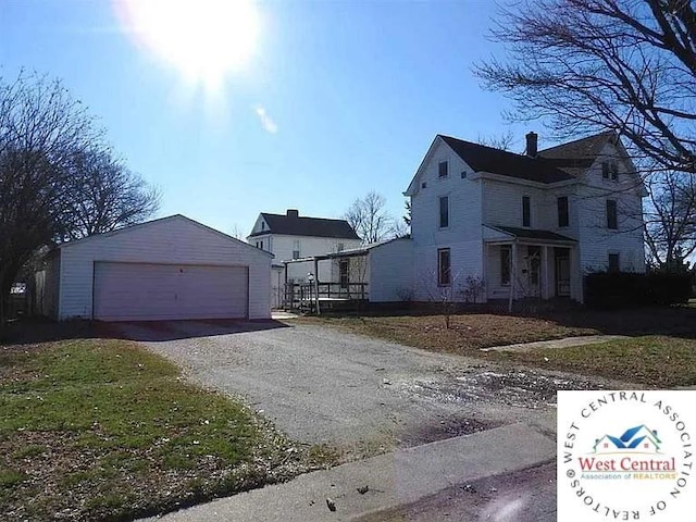 view of side of property with an outdoor structure, a garage, and a chimney