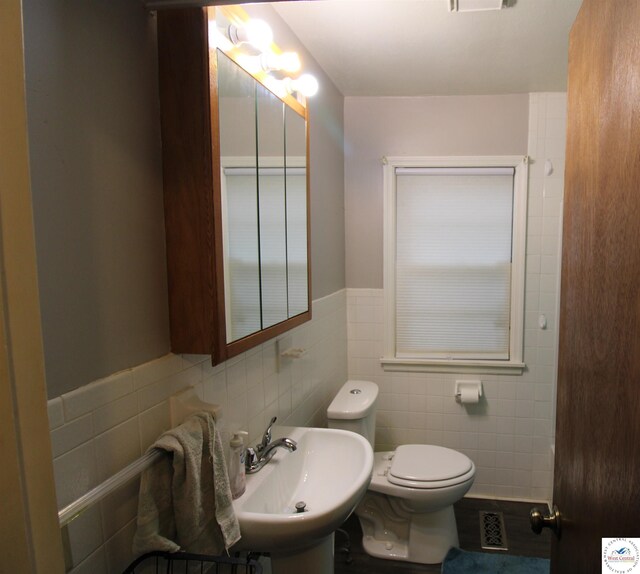 101 Lakeveiw Dr, Windsor, MO 65360 - bathroom with tile walls, a sink, toilet, and wainscoting
