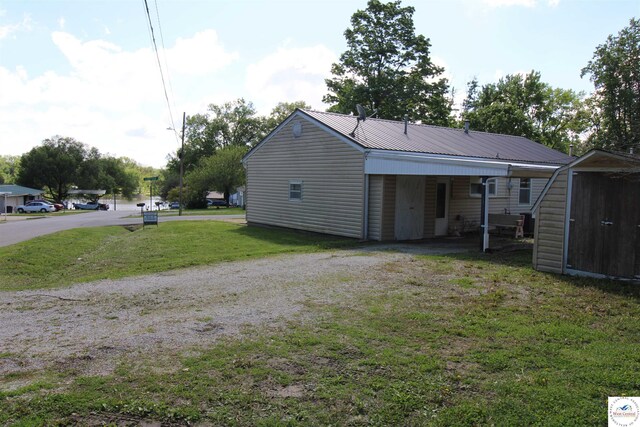 101 Lakeveiw Dr, Windsor, MO 65360 - back of property featuring dirt driveway, a yard, an attached carport, and metal roof